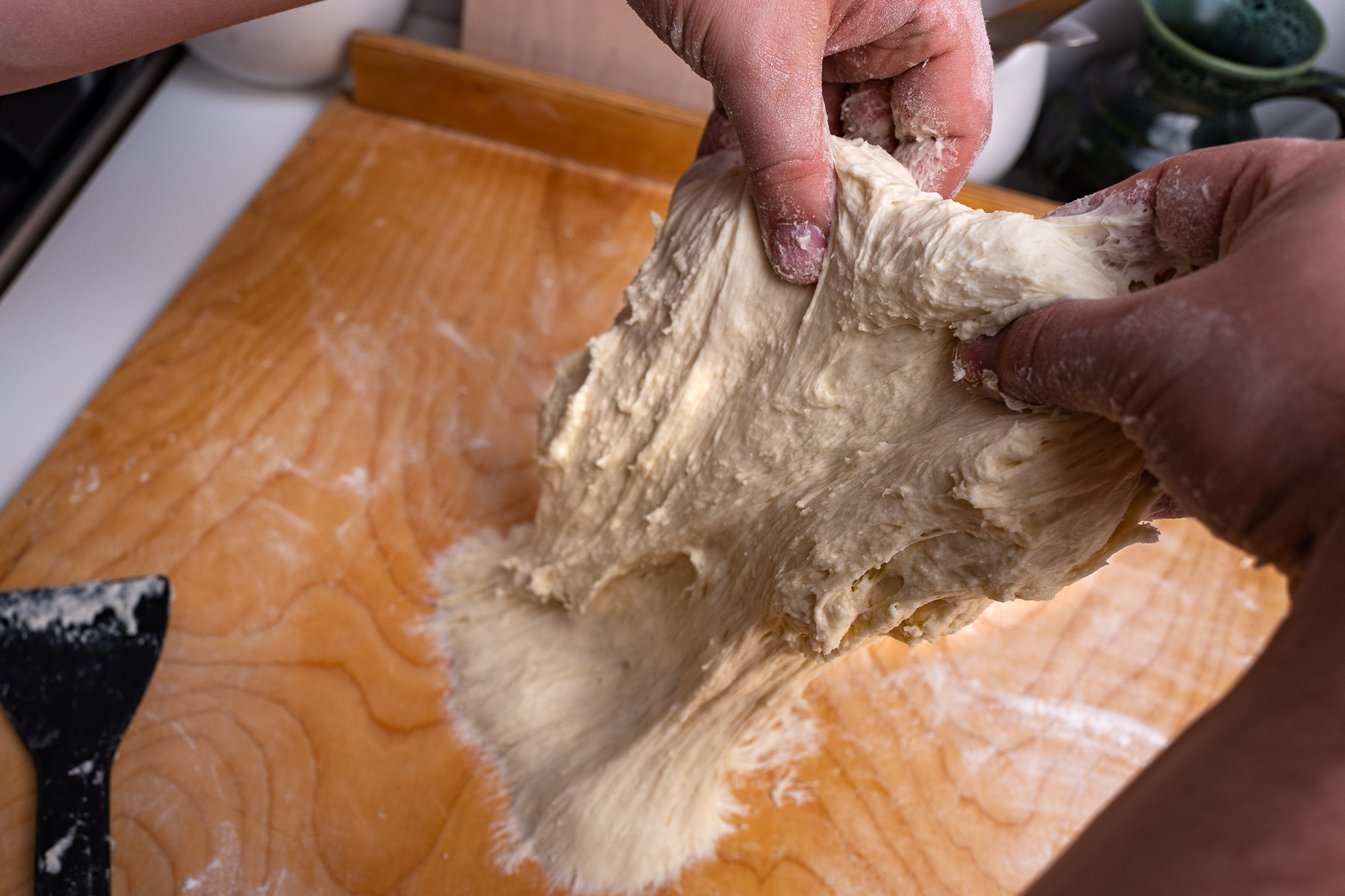 ciasto po wchłonięciu całej mąki z blatu zacznie się kleić - należy wyrabiać je rozciągając do góry i zawijając na pół