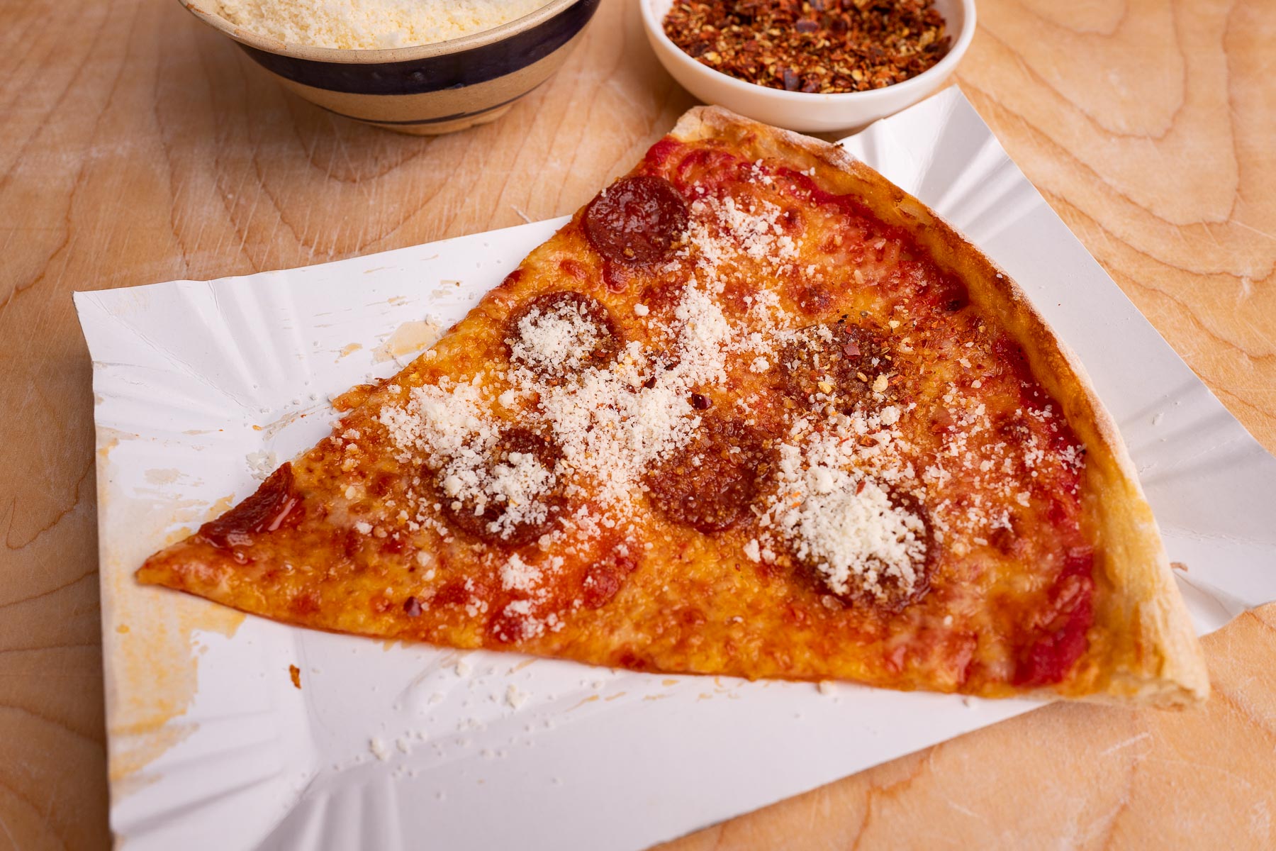 pizzę możemy wedle uznania doprawić dodatkami takimi jak tarty parmezan czy płatki chilli