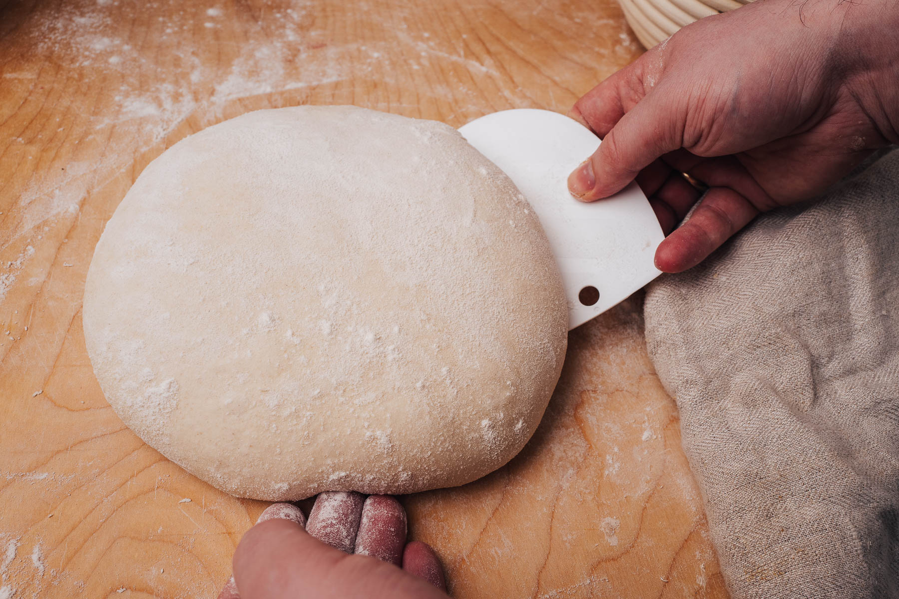 Podsyp ciasto mąką i używając skrobaczki obróć je do góry nogami.